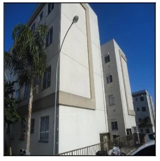 Apartamento branco no Residencial Carducci com 2 quartos e janela aparente em área urbana com árvores próximas