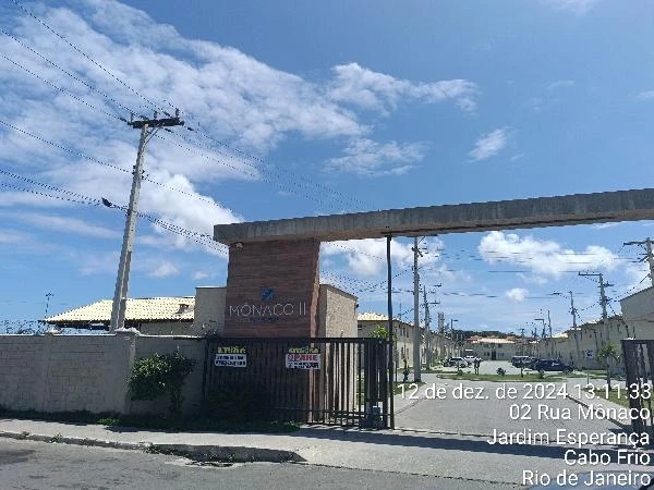 Apartamento residencial com portão automatizado em condomínio no Jardim Esperança Cabo Frio céu azul e ruas asfaltadas