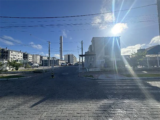 Apartamento branco em condomínio residencial com sol forte e céu azul sem avarias visíveis