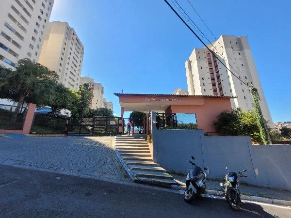 Apartamento branco no Condomínio Residencial Premmio Vila Nova com entrada principal e motos estacionadas na fachada