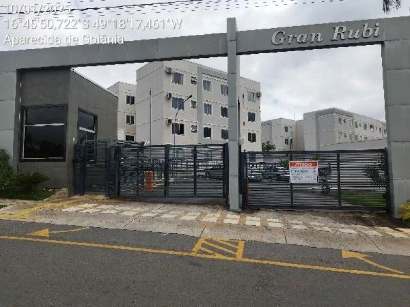 Apartamento de cor clara no condomínio Residencial Gran Rubi com portão de metal preto e fachada em dia nublado