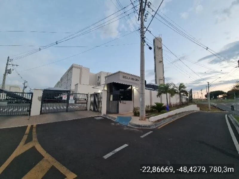 Apartamento no Condomínio Residencial Bella Hungria com fachada branca e guarita de segurança na entrada principal