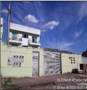 Apartamento verde claro com varanda e garagem em condomínio residencial, fachada com pintura e estrutura simples