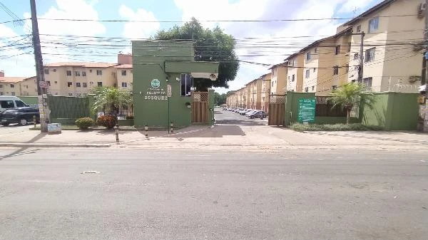 Apartamento com fachada verde e guarita em condomínio residencial com prédios e carros em estacionamento