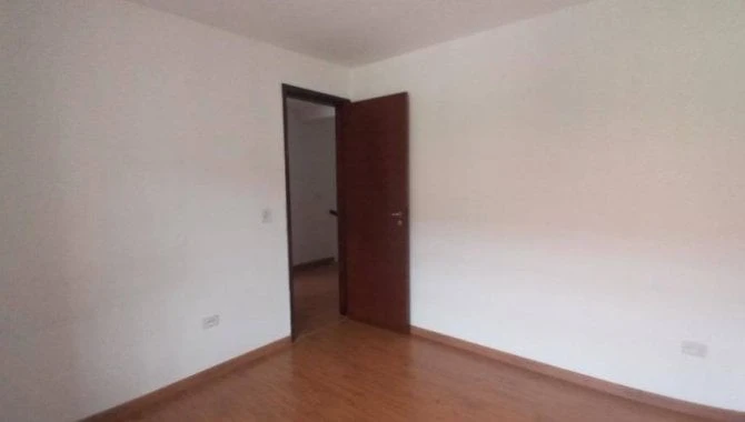 Casa residencial com piso de madeira clara parede branca porta marrom vista interna e ambiente vazio