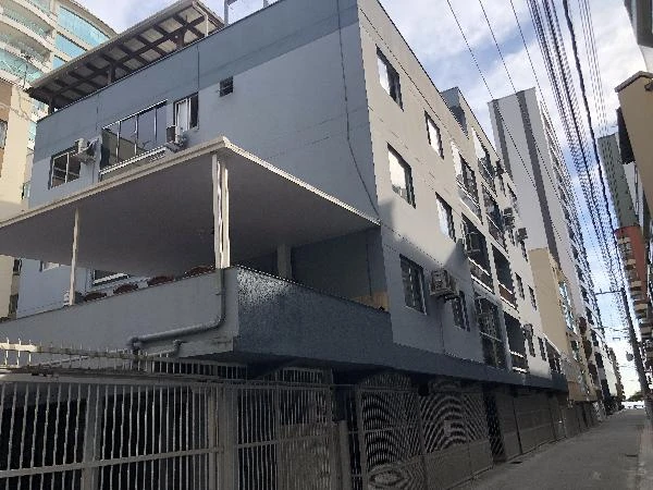 Apartamento cinza com varanda e janelas em prédio residencial de 3 andares em área urbana