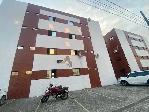 Apartamento fachada com pintura branca e marrom em condomínio com vagas demarcadas e motocicleta estacionada