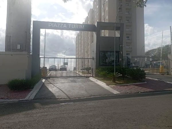 Apartamento residencial com portaria com portão de ferro em condomínio com prédios altos e área pavimentada