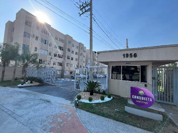 Apartamento bege em condomínio Conquista Jardins com portaria e área externa ensolarada