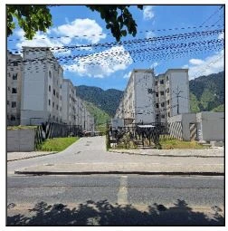 Apartamento branco em condomínio residencial com várias torres e grade na entrada com vista para montanhas ao fundo