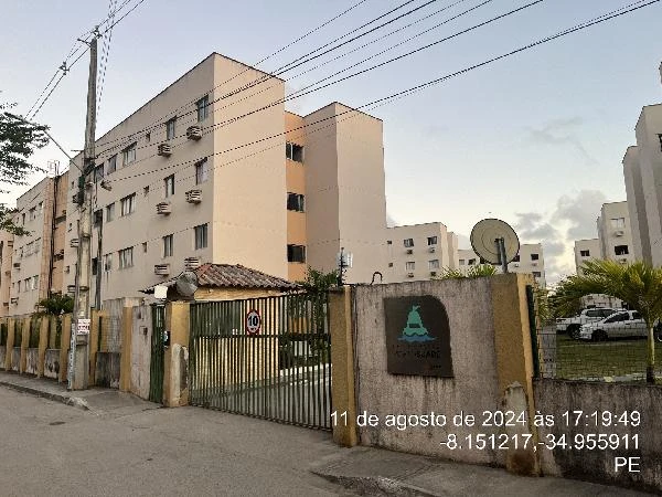 Apartamento em prédio residencial bege com cerca e portão de ferro no Condomínio Residencial Porto Suape em área urbana