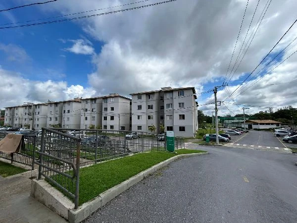 Apartamento branco com quatro andares em condomínio com estacionamento e área de entrada