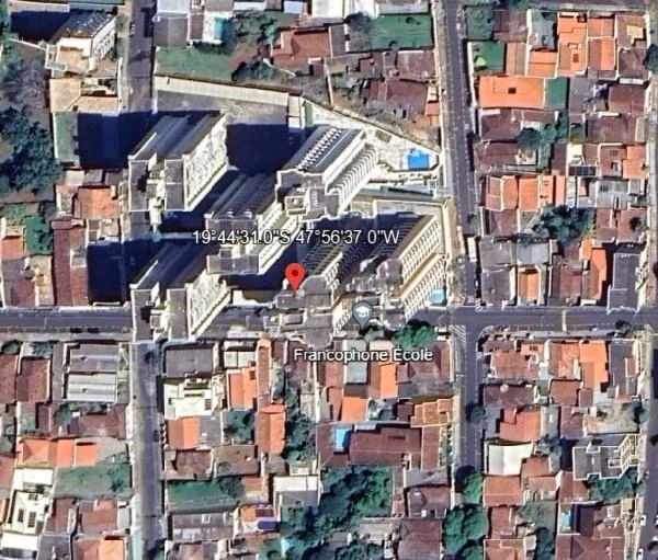 Apartamento em condomínio com vários blocos residenciais visto de cima em área urbana cercada por casas