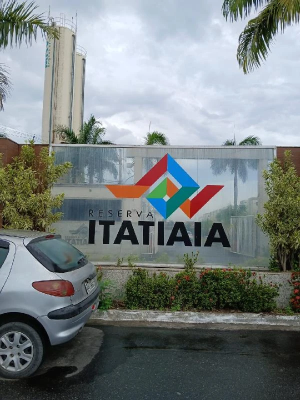 Apartamento prateado estacionado em frente à placa do Parque Reserva Itatiaia em área residencial