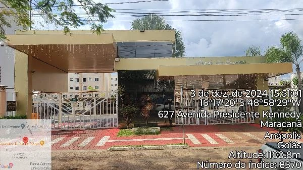 Apartamento bege com vista da fachada principal e portaria em condomínio residencial no entorno urbano