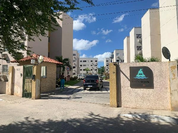 Apartamento branco de 44m² no condomínio residencial Porto Suape com guarita de acesso e área externa urbana