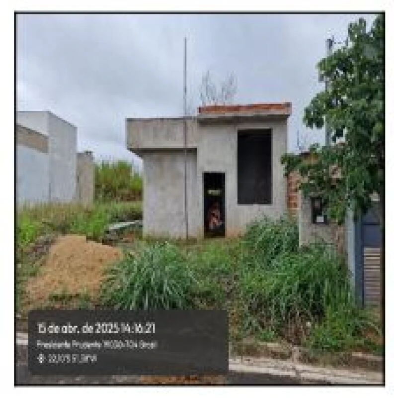 Terreno com área de 160m² em fase inicial de construção com vegetação ao redor e fachada inacabada